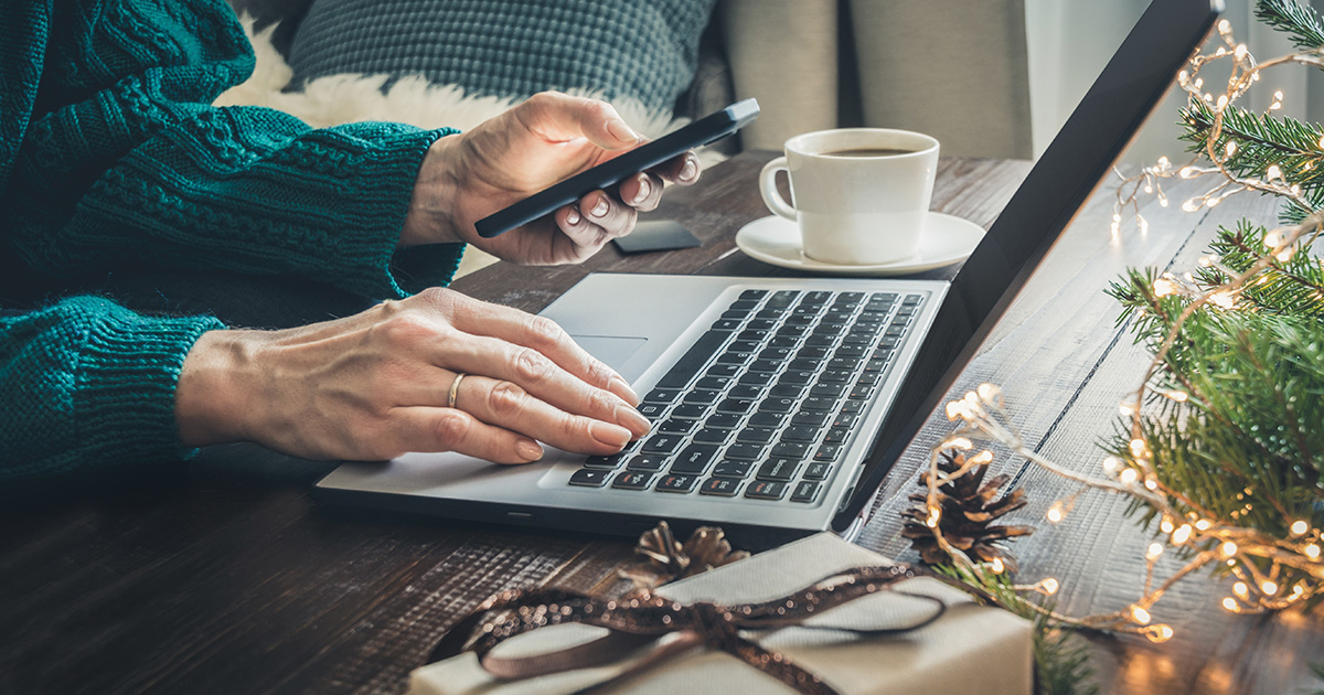 personne payant avec sa carte de crédit par un ordinateur portable, bureau avec décoration de Noël