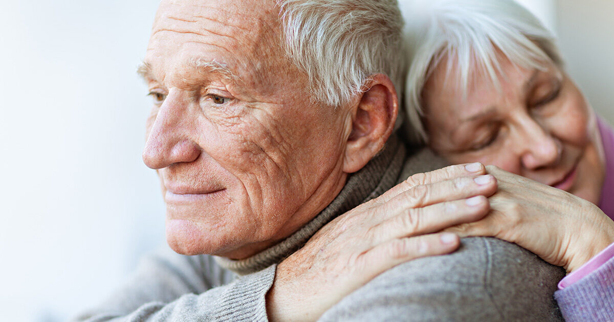 homme cheveux blancs environ 70 ans, femme agée environ 70 ans dans les bras l'un de l'autre