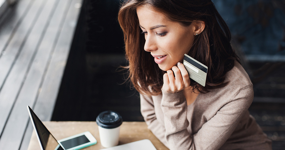 Infosolvabilité femme fin trentaine souriante travaillant devant un ordinateur